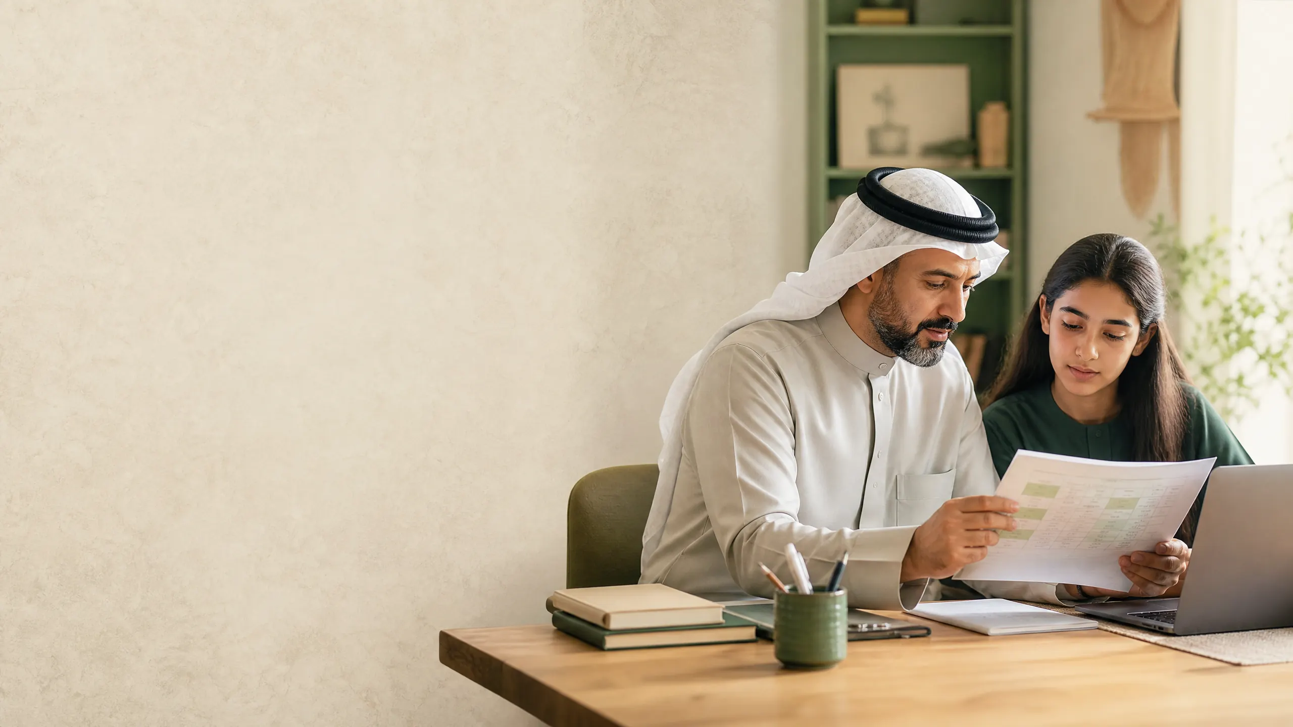 ولي أمر وطالبة يراجعان مواد دراسية بهدوء
